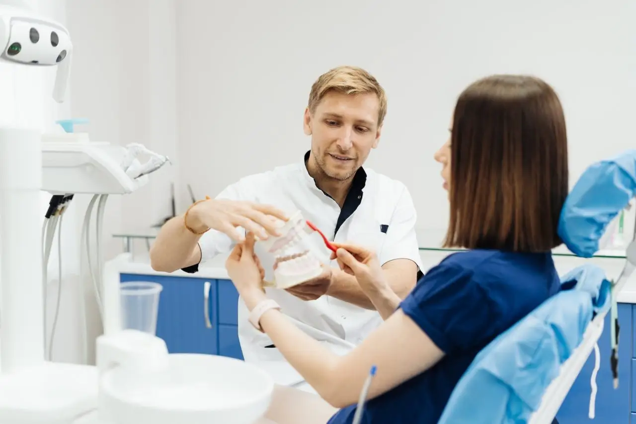 Dentist demonstrating proper flossing technique for a patient in Milpitas, CA